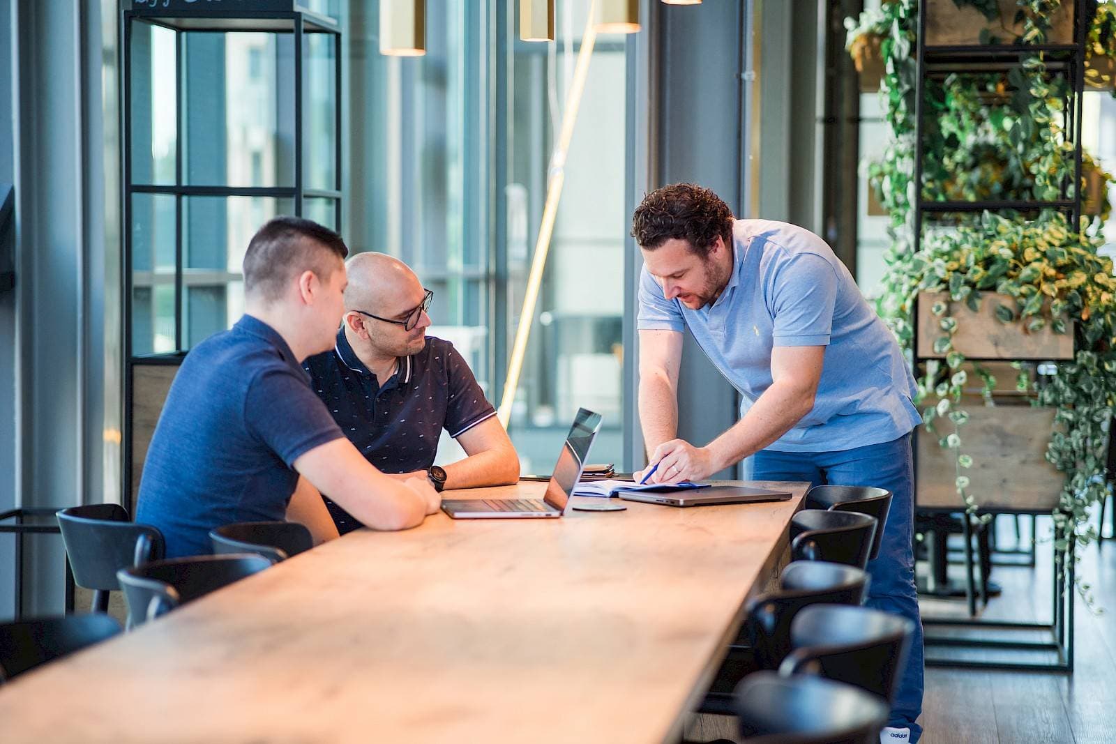 Three colleagues discussing content around a table